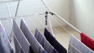 Yazın evde, balkonda kimliği belirsiz beyaz bir kadın tarafından asılıp kurutulmaya bırakılan telle çamaşır makinesini kapat. Ev işi kavramı.