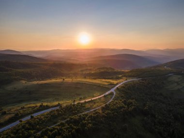 Yaz akşamında gün batımında hava aracı görüntüsü - Gün sonunda dağların arkasında güneş