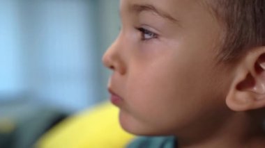 Çiğneyen küçük beyaz çocuğun yakın portresi - küçük çocuk yüzünü evde yiyor kameraya bakıyor yüz ifadeleri yapıyor - çocukluk konsepti aile hayatı