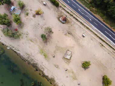 Brza Palanka kasabasındaki Tuna nehri kıyısındaki kumsal sahili üzerinde yaz gününün yanında ana yolu bulunan havadan aşağıya doğru manzara. Kopya uzayı ile özgürlük doğa yolculuğu kavramı.
