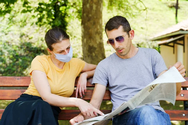 夏天的一天 两个男人和一个女人的朋友或一对夫妇坐在长椅上 戴着防护面具 这是新的正常社交距离眼镜 科罗纳维斯的概念 — 图库照片