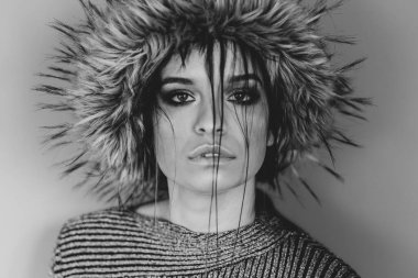 Kafkasyalı güzel bir kızın portresi. Moda mankeni. Kafasında tüylü bir şapka, yüzünde saçı olan.