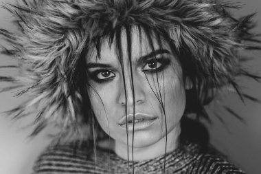 Kafkasyalı güzel bir kızın portresi. Moda mankeni. Kafasında tüylü bir şapka, yüzünde saçı olan.