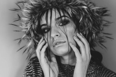 Kafkasyalı güzel bir kızın portresi. Moda mankeni. Kafasında tüylü bir şapka, yüzünde saçı olan.