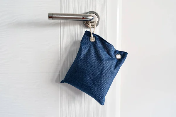 Close up on air purify bag charcoal activated carbon moisture absorber and odor eliminator hanging on the door in apartment at home to maintain freshness and clear smell