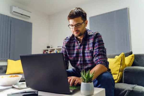 Evdeki dizüstü bilgisayarda çalışan genç beyaz bir adam gece geç saatlere kadar tek başına çalışan bir muhasebeci iş ve finans konsepti.