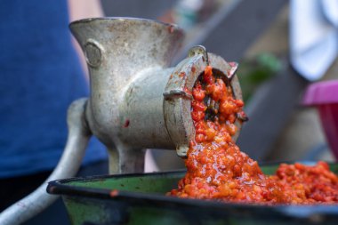 Balkan 'da ayvar ulusal yemeği için kırmızı biber hazırlayan sebzelerle öğütücü değirmenini kapatın - sağlıklı organik gıda kavramı