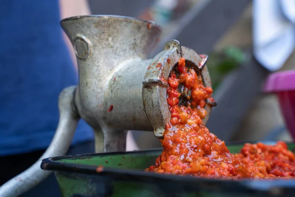 Balkan 'da ayvar ulusal yemeği için kırmızı biber hazırlayan sebzelerle öğütücü değirmenini kapatın - sağlıklı organik gıda kavramı
