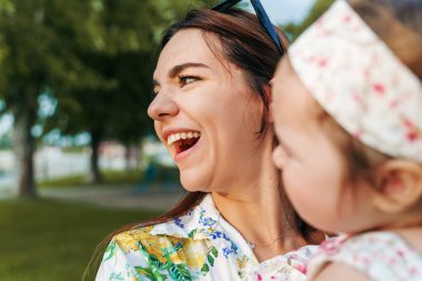 Sonbahar ya da yaz günü çocuğuyla birlikte mutlu beyaz bir kadının yanına yaklaşın. Bekar bir anne, küçük kızını kucaklarken birlikte eğleniyor. Gerçek insanlar bağ kuruyor ve eğleniyor.