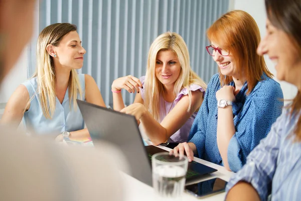 Bir grup kadın sadece iş yerinde dizüstü bilgisayarla masa başında çalışan iş arkadaşları - Milenyum patronu ve girişimcileri beyin fırtınası konseptini tartışıyorlar