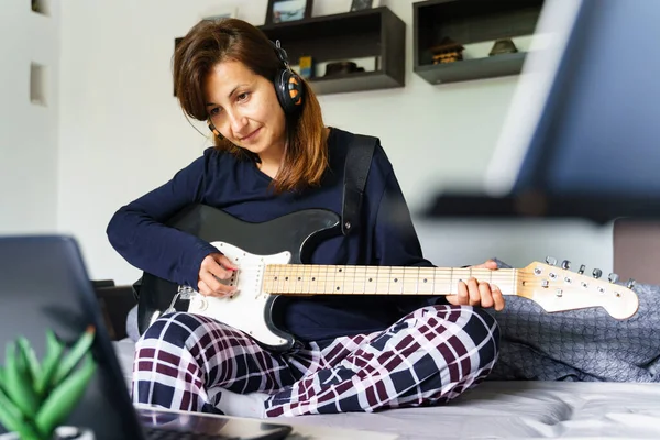 Yetişkin Beyaz Bir Kadının Yatak Odasında Oturup Elektronik Gitar Çalmayı — Stok fotoğraf