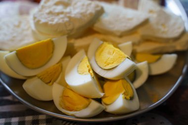 Tabakta servis edilen haşlanmış yumurta ve peynire yakından bakın. Yemeye hazır. Çiftlikte taze ev yapımı organik yiyecekler.