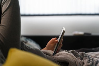 Cep telefonunu kapat. Bilinmeyen beyaz bir kadının elinde. Evde yatakta uzanan, boş zamanlarında internet gezen, sosyal medyada vakit geçiren, akıllı telefonlara odaklanan antisosyal konsept.