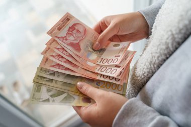 Bilinmeyen Kafkas kadınlarının ellerinde bir yığın para tutarken ve sayarken Sırp dinarı RSD banknotları maaş artışlarını sayarken ya da faturaları ödemeye hazırlanırken.