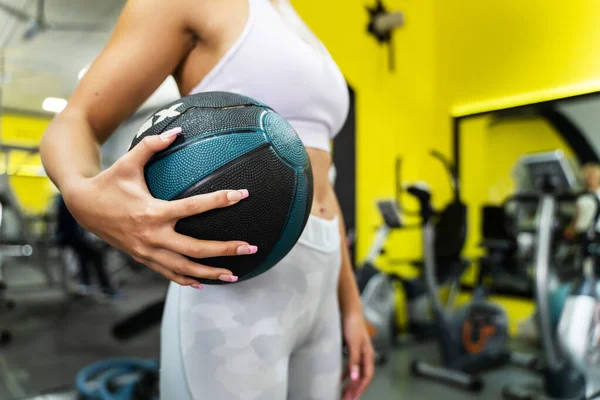 一位不知名的高加索女人站在体操中心举着医学球 健康与健康的概念 — 图库照片