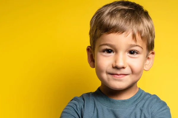 カメラを見る黄色の背景の前に幸せな喜びの小さな白人の少年の肖像 子供の頃の成長と概念 フロントビューの腰のコピースペース — ストック写真