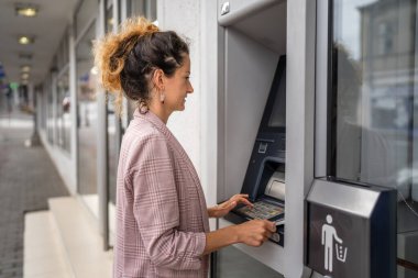 Kadın kredi kartı kullanıyor ve ATM 'den para çekiyor.