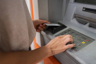 Kredi kartı kullanan ve ATM 'den para çeken bir kadının elleri.