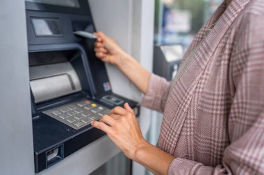 Kredi kartı kullanan ve ATM 'den para çeken bir kadının elleri.