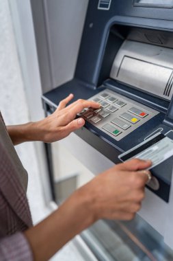 Kredi kartı kullanan ve ATM 'den para çeken bir kadının elleri.
