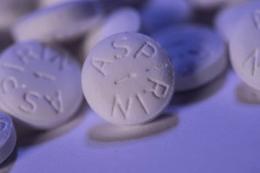 White Aspirin macro shot on blue background clipart