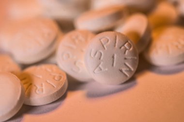 White Aspirin macro shot on orange background clipart