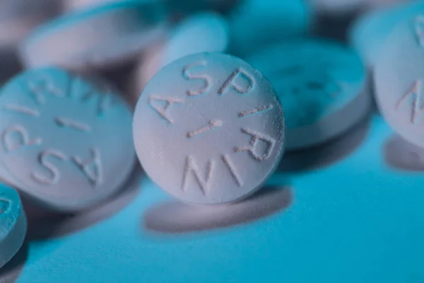 White Aspirin macro shot on aqua blue background Stock Image