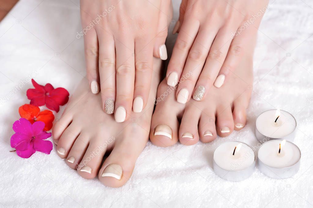 Relaxing pedicure and manicure with a red flowers and candles. Close up, selective focus