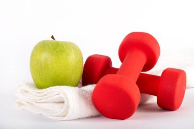 Kırmızı dumbbell ve havlu Studio beyaz zemin üzerine Yeşil taze elma. Spor, fitness, diyet ve sağlık gıda kavramı