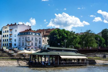 Niş, Sırbistan - 16 Mayıs 2018: Yüzen restoran güneşli gün ve şehir manzarası Nisava nehrinde. Niş, Sırbistan şehirde bulunan turistik