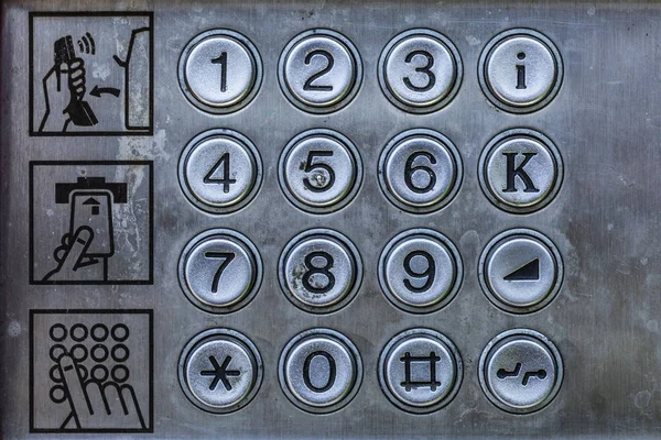 Old telephone booth metal numbers and user manual. Close up, retro and vintage concept