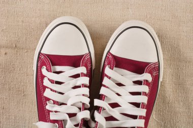 Eski kumaş retro arka plan üzerinde kırmızı spor ayakkabılar. Yakın çekim, görünümü top. Retro moda kavramı