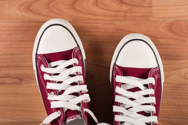 Çift ahşap zemin üzerinde kırmızı spor ayakkabı. Yakın çekim, görünümü top. Retro moda kavramı.