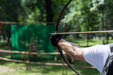 Archer el ahşap yay ile ok vur. Ormandaki okçuluk turnuvası. Daha önce bir uzun menzilli çekim okçu. Yakın, seçici odak