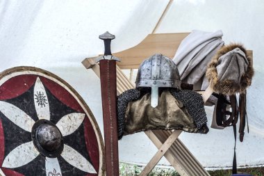 Ortaçağ şövalyesi ekipman eski uyku çadırda. Metal miğfer, kalkan, kılıç ve elbiseleri sandalyeye. Geleneksel şövalyeler silah orta yaş Tema Festivali