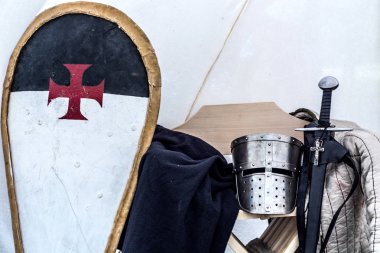 Ortaçağ şövalyesi ekipman eski uyku çadırda. Metal miğfer, kalkan, kılıç ve elbiseleri sandalyeye. Orta yaş Tema Festivali'nde geleneksel şövalyeler silah. Yakın, seçici odak