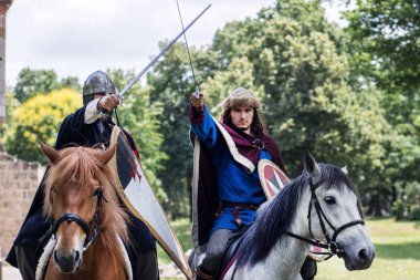 Niş, Sırbistan - 10 Haziran 2018: İki atı atlar ve ormandaki zam kılıç zırh. Orta Çağ kavramı