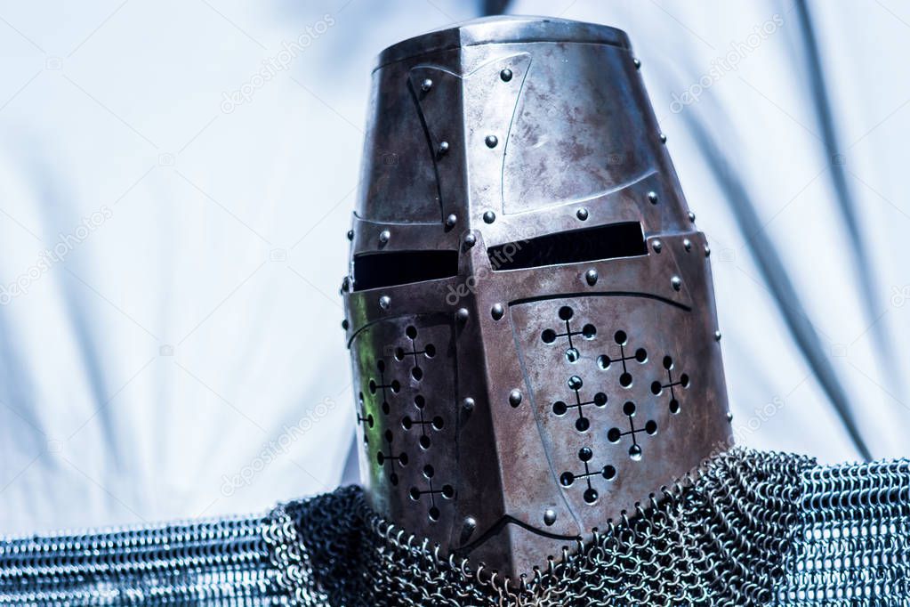 Medieval old knight helmet and chain mail for protection in battle. Very heavy headdress on stand. Middle ages armor concept