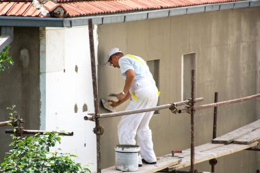 Niş, Sırbistan - 16 Haziran 2018: Isı yalıtım dış cephe panel ev. Çalışan adam cephe duvar yüksek katlı bina yalıtır