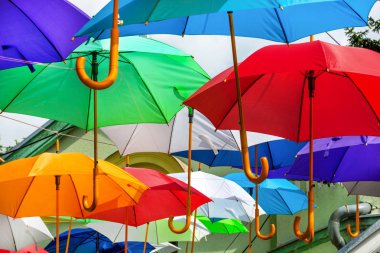 Renkli şemsiyeler kentsel sokak dekorasyon. Renkli şemsiyeler mavi gökyüzü, turistik güneşli üzerinde asılı. Yakın, seçici odak