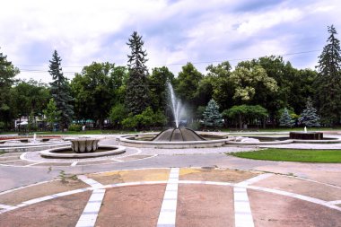 Niska Banja, Sırbistan - 02 Temmuz 2018: Büyük parkta yürüyüş yolu ve çeşme ile spa resort. Dramatik mavi bulutlu gökyüzü doğa sağlık Park