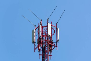Telekomünikasyon kule mavi gökyüzü ile kırmızı antenler ile kapatın. Hareket eden telefon iletişim donanımları kavramı.