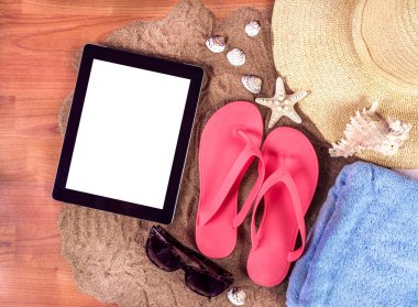 Yaz flip flop, havlu, deniz yıldızı ve gözlük ile dijital tablet bilgisayar ile beyaz perde için örnek metin kum ve ahşap tahta üzerinde arka plan. Tatil tatil kavramı görüntü. Yakın çekim, görünümü top