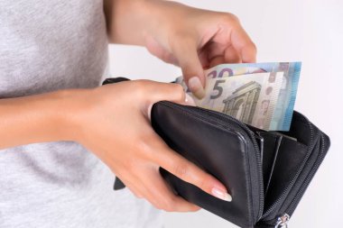 Genç kadın holding siyah m-cüzdan ile Euro para ve ödeme eller. Ekonomi ve alışveriş kavramı. Yakın, seçici odak