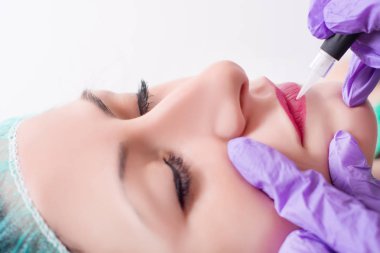 Profesyonel uygulanan kalıcı makyaj kadın dilinde yordam. Güzellik salonunda dövme getting genç güzel kız. Yakın, seçici odak