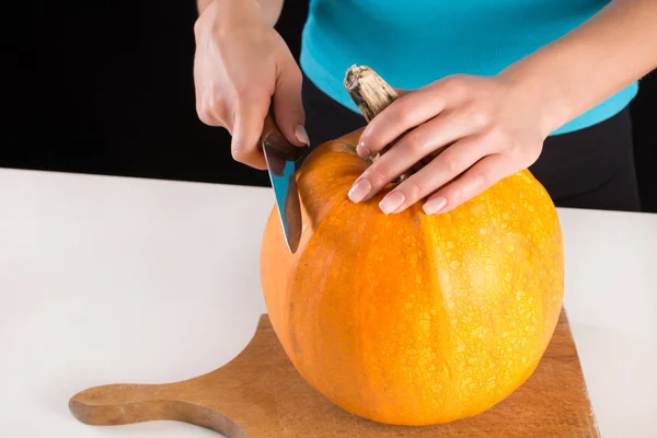Frau Mit Messer Schneidet Kürbis Auf Holzbrett Für Halloween Feiertage — Stockfoto
