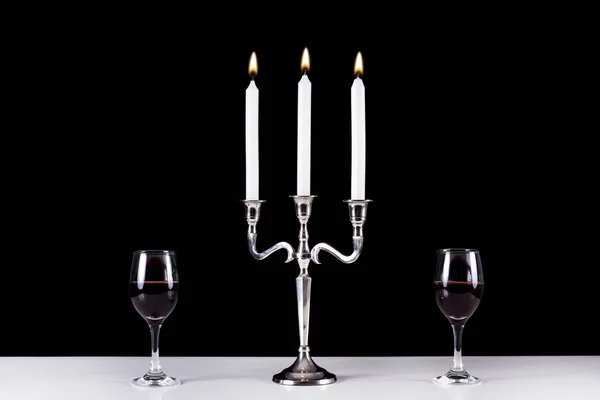 スタイリッシュなシルバー バロック ローソク足と白い机と黒の背景に つ赤ワイングラス ロマンティック食堂コンセプト — ストック写真