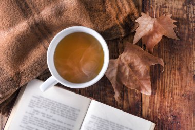 Fincan çay ve retro eşarp ve resepsiyon düşmüş yaprak ile ilgili kitap. Sonbahar retro ve vintage kavramı arka plan. Ana sayfa görünümü, yukarı ve seçici yakın odak