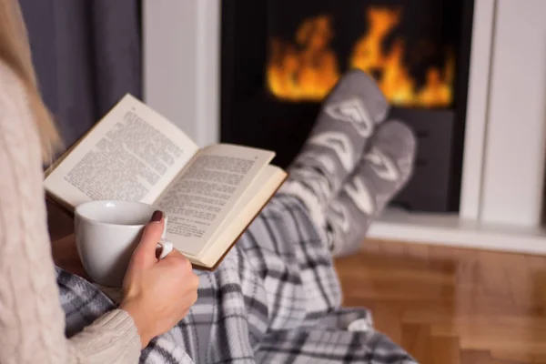 Girl Front Fireplace Reading Book Warming Feet Fire Legs Covered — Stock Photo, Image