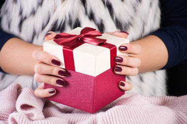 Kırmızı hediye mevcut kutusu ile kravat yay elinde tutan kız. Kürk yelek zebra desenli kadında. Noel ve yeni yıl tatil kavramı. Yakın, seçici odak